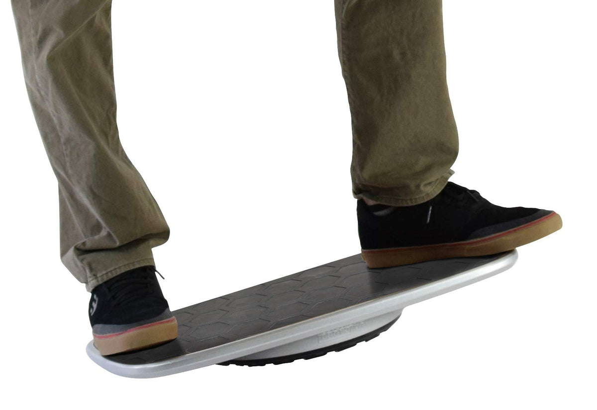 Person standing on black and white balance board showing side profile