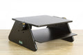 Black monitor stand side angle view on wooden desk