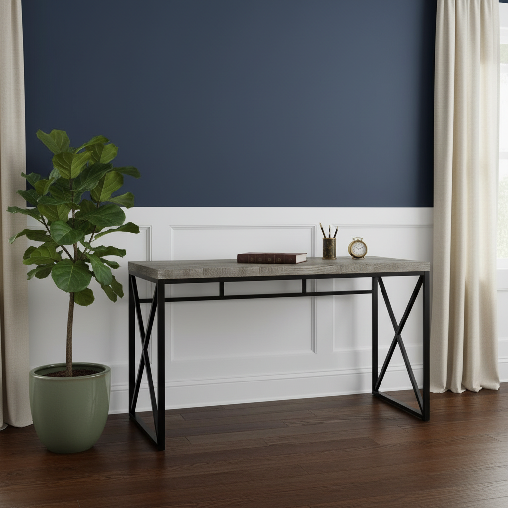Gray and black computer desk against a navy wall with a plant