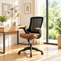 Black mesh and brown faux leather office chair in a sunny home office