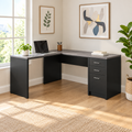 Gray and black L-shaped computer desk with 3 drawers in a bright home office