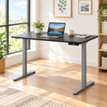 Black and gray adjustable standing desk in a bright home office