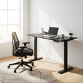 Black adjustable computer desk in a bright home office